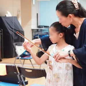 バイオリンを練習する子どもとサポートする親