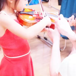 バイオリンを練習する子どもとサポートする親