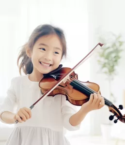 笑顔でバイオリンを弾く子ども